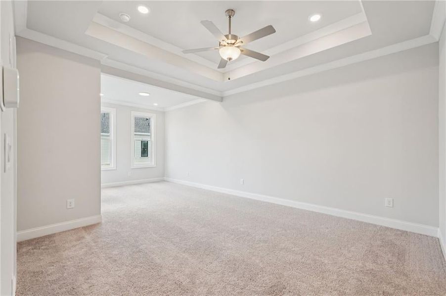 Empty room featuring a ceiling fan, light carpet, crown molding, and recessed lighting