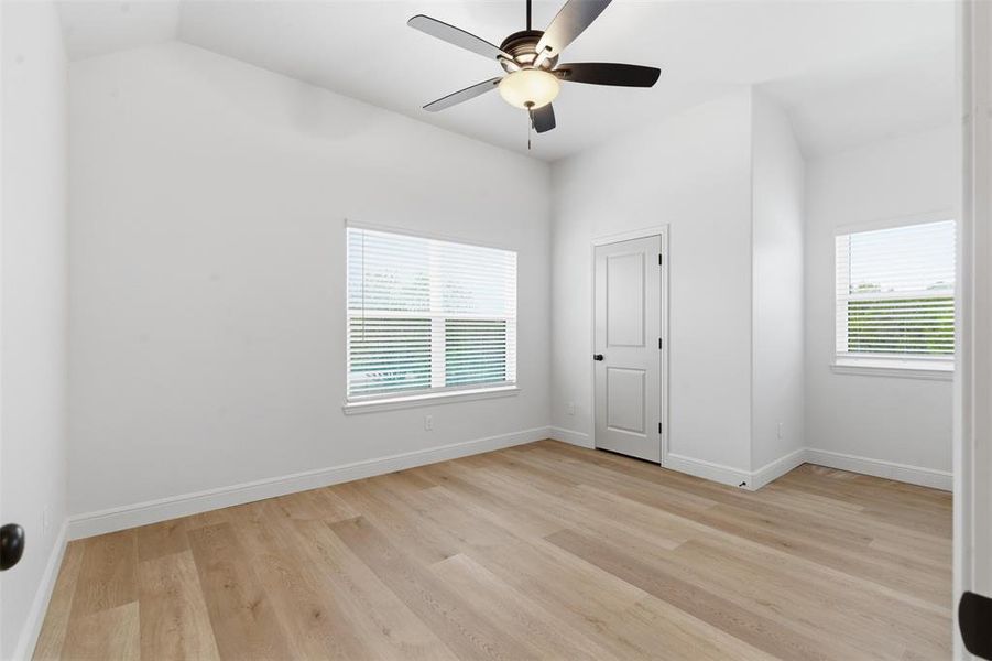 Unfurnished bedroom with light wood-type flooring and a ceiling fan Unfurnished bedroom with light wood-type flooring and a ceiling fan