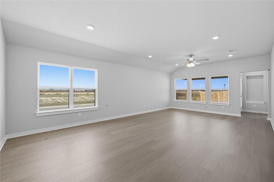 Empty room with recessed lighting, light wood finished floors, vaulted ceiling, and ceiling fan Empty room with recessed lighting, light wood finished floors, vaulted ceiling, and ceiling fan