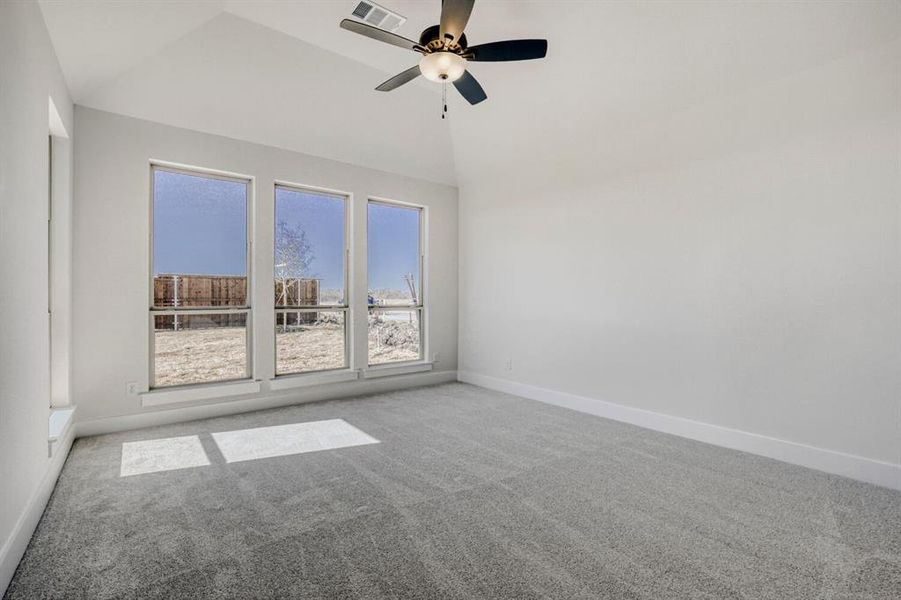 Spare room with light colored carpet, ceiling fan, and vaulted ceiling