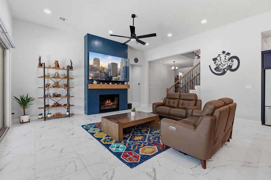 A well-lit living space features a modern fireplace and elegant marble-patterned flooring. A well-lit living space features a modern fireplace and elegant marble-patterned flooring.