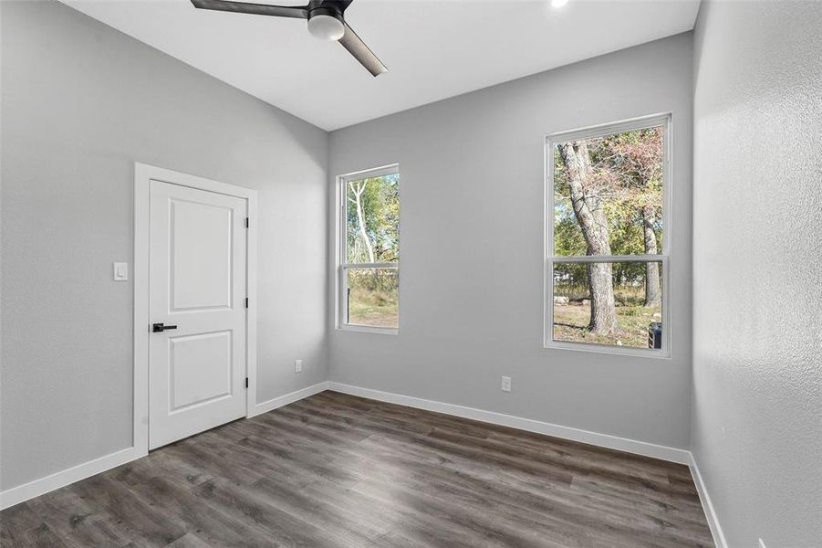 Unfurnished room with dark hardwood / wood-style flooring and ceiling fan