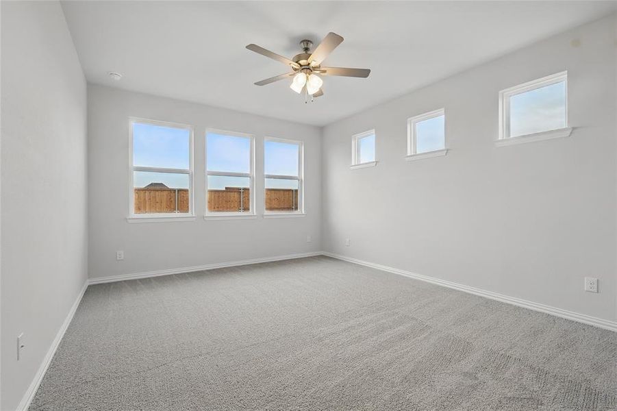 Empty room with carpet and a ceiling fan Empty room with carpet and a ceiling fan