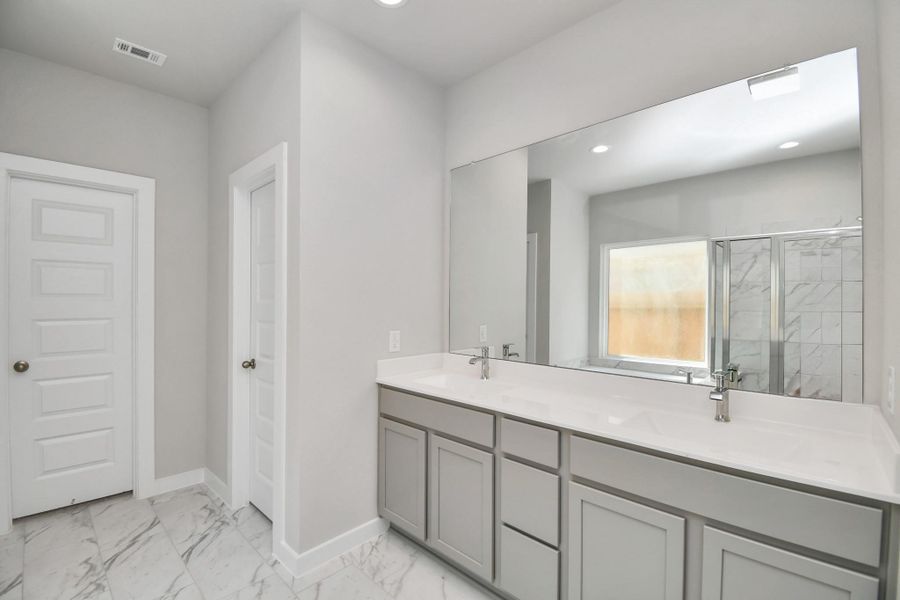 Escape to a spa-like oasis in this primary bathroom. Enjoy a walk-in shower with tile surround, a separate garden tub with custom detailing, and an elegant vanity featuring light countertops, modern hardware, and beautiful recessed lights. Experience luxury and relaxation in every detail. Escape to a spa-like oasis in this primary bathroom. Enjoy a walk-in shower with tile surround, a separate garden tub with custom detailing, and an elegant vanity featuring light countertops, modern hardware, and beautiful recessed lights. Experience luxury and relaxation in every detail.