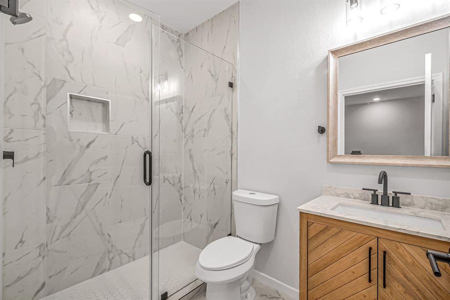 Second floor guest bath also has a seamless glass shower enclosure.