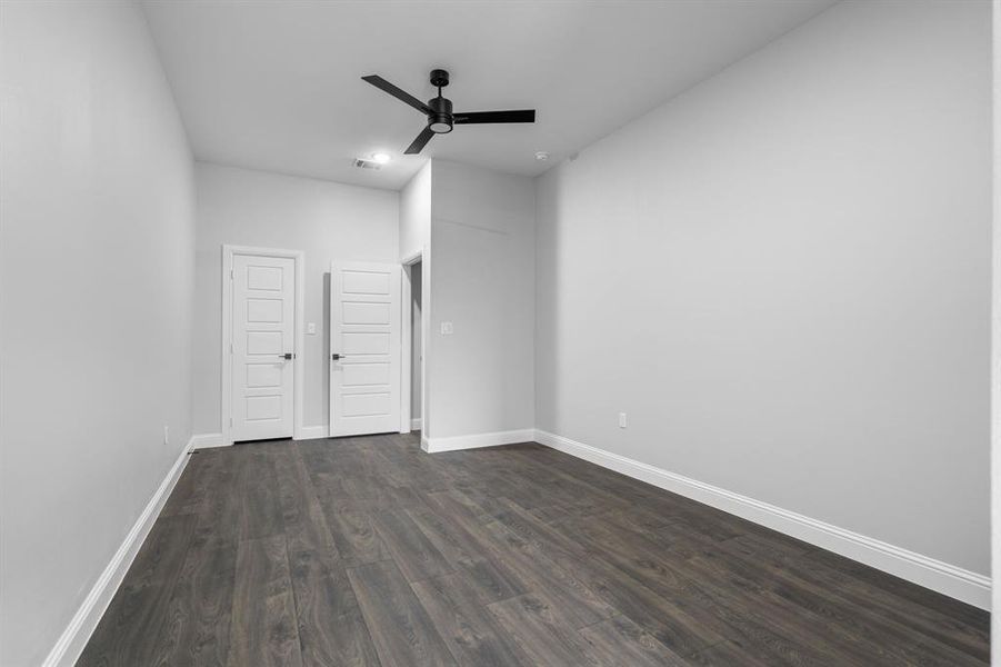 Spare room with dark hardwood / wood-style flooring and ceiling fan