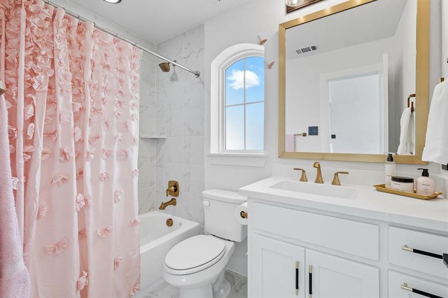 Upstairs ensuite bathroom with shower / tub combo and vanity with gold touches Upstairs ensuite bathroom with shower / tub combo and vanity with gold touches