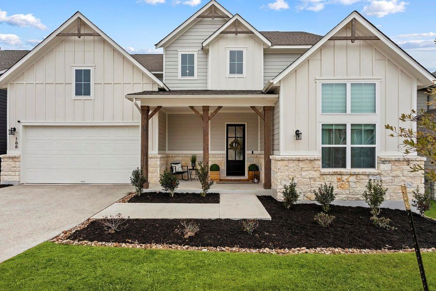 View of front of property with a garage, covered porch, and a front yard