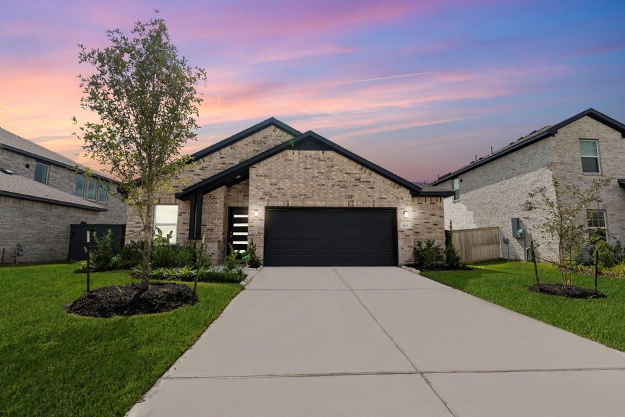 Stunning twilight view of this beautiful brick home showcasing glowing skies and elegant curb appeal. The soft evening light highlights the clean lines and modern design, creating a warm and welcoming first impression that feels truly special.