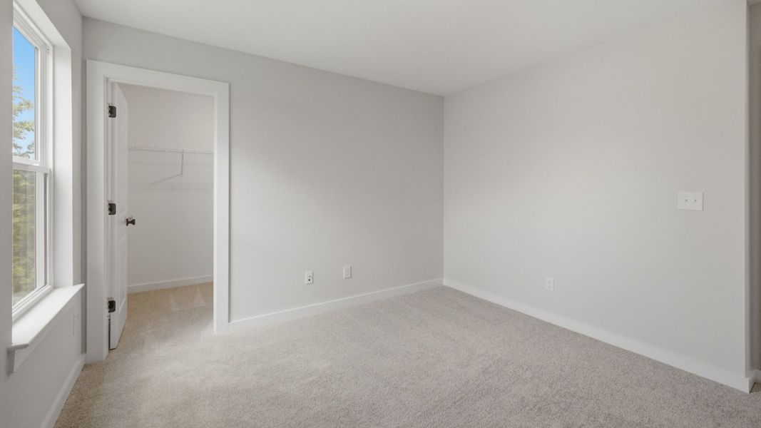 Secondary bedroom with carpet, window, and closet
