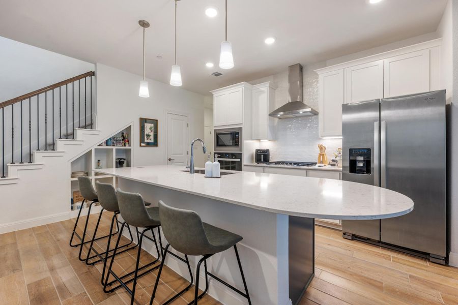 A contemporary kitchen features an inviting breakfast bar island and sleek stainless steel appliances. A contemporary kitchen features an inviting breakfast bar island and sleek stainless steel appliances.