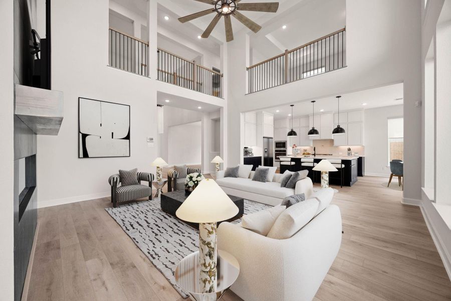 A comprehensive perspective of the grand family room, beautifully showcasing the home's multi-level architectural design. This angle highlights the dramatic wrap-around upstairs catwalk with elegant wrought-iron spindles that overlook the entire main living space. From here, the seamless integration with the bright gourmet kitchen, central prep island, and adjacent dining spaces is fully visible, emphasizing the ultimate open-concept layout tailored for modern living. *Virtually Staged A comprehensive perspective of the grand family room, beautifully showcasing the home's multi-level architectural design. This angle highlights the dramatic wrap-around upstairs catwalk with elegant wrought-iron spindles that overlook the entire main living space. From here, the seamless integration with the bright gourmet kitchen, central prep island, and adjacent dining spaces is fully visible, emphasizing the ultimate open-concept layout tailored for modern living. *Virtually Staged
