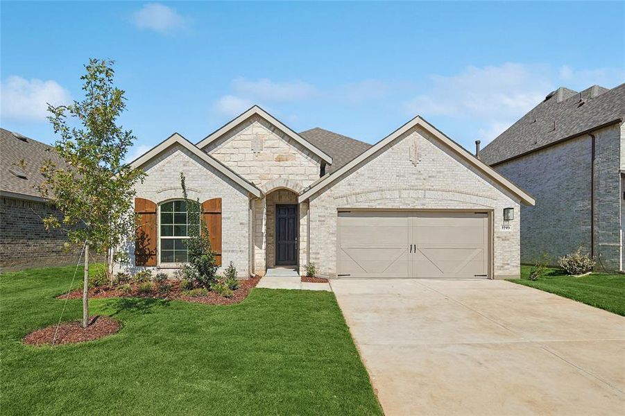 View of front facade featuring a front yard and a garage