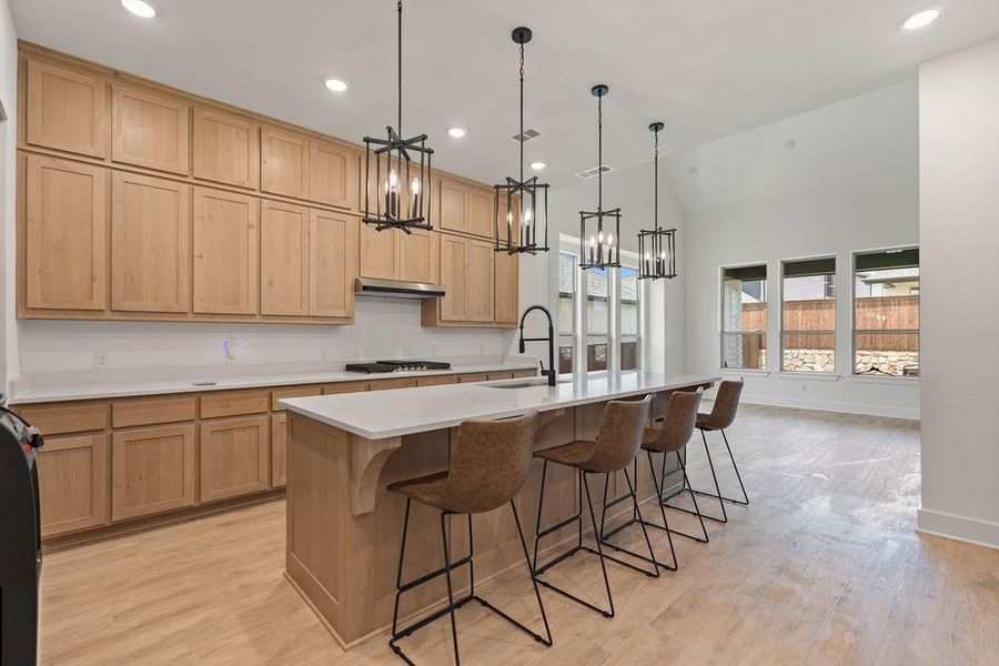 Kitchen featuring light wood-finish cabinetry, white countertops, and a central island with pendant lighting Kitchen featuring light wood-finish cabinetry, white countertops, and a central island with pendant lighting