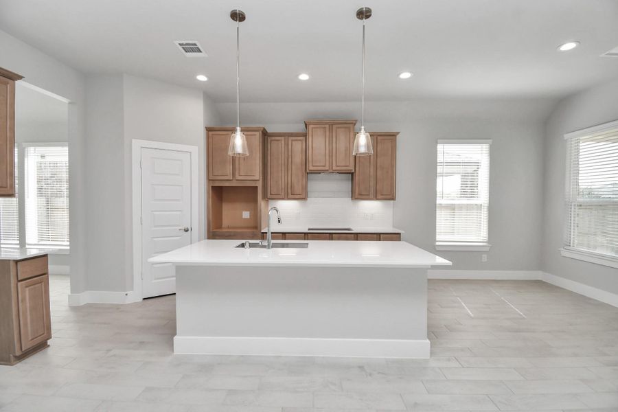 This kitchen is by far any chef’s dream! This spacious kitchen features high ceilings, light stained wood cabinets, granite countertop, SS appliances, modern tile backsplash, recessed lighting, extended counter space, granite kitchen island with double sink, and space for breakfast bar, and a walk-in pantry all overlooking your huge family room. Sample photo of completed home with similar floor plan. Actual colors and selections may vary.