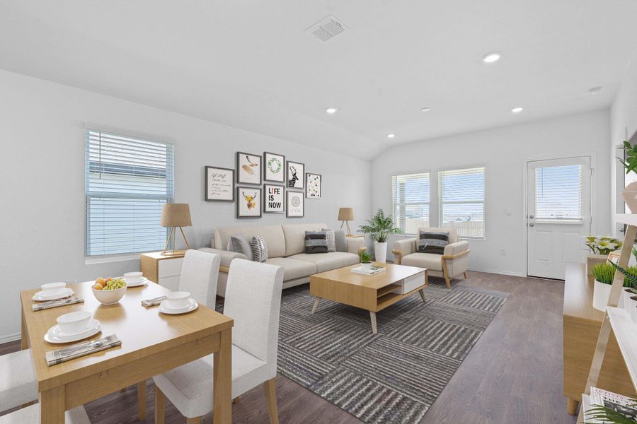Living area featuring wood finished floors, plenty of natural light, recessed lighting, and vaulted ceiling