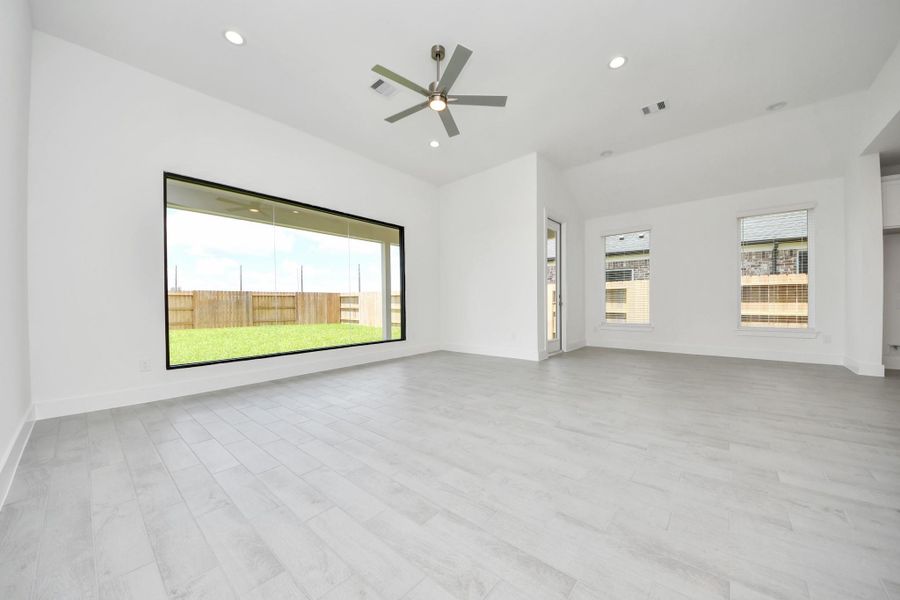 Gather the family and guests together in your lovely living room! Featuring soaring high ceilings, recessed lighting, ceiling fan, custom paint, gorgeous floors, and large windows that provide plenty of natural lighting throughout the day.