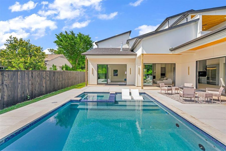 View of swimming pool featuring a patio and an in ground hot tub