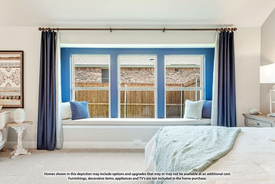 Bedroom with built-in window seat, three windows, blue accent wall, and dark curtains