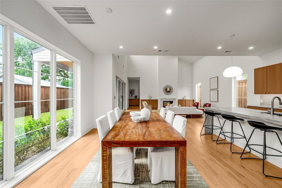 Open-concept interior featuring light wood-finish flooring, a vaulted ceiling, and a kitchen island with seating