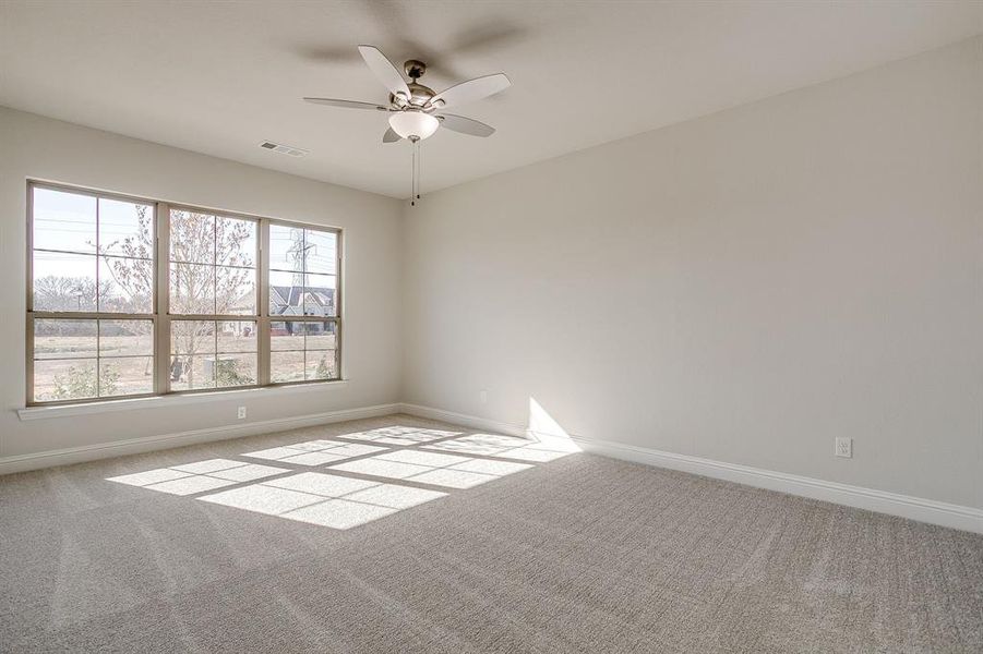 Empty room with light carpet and ceiling fan