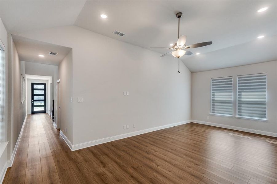Unfurnished room featuring vaulted ceiling, wood finished floors, a ceiling fan, and recessed lighting Unfurnished room featuring vaulted ceiling, wood finished floors, a ceiling fan, and recessed lighting