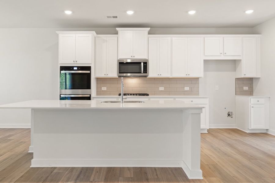 A kitchen with white cabinets.