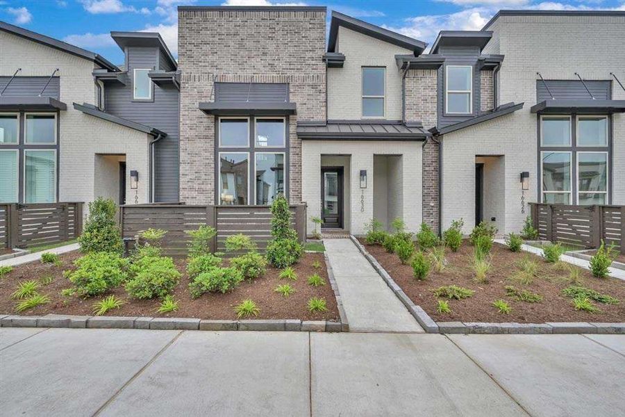 Modern brick and siding exterior with Urbane Bronze metal accents and clean landscaping.