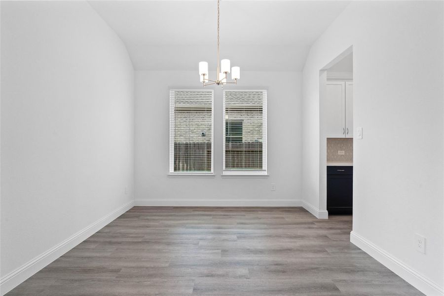 You and your guests will certainly dine in style in this amazing formal dining room! Featuring a gorgeous modern chandelier, large window with blinds, neutral paint, high ceilings, and luxury vinyl flooring! Perfect space to entertain family and friends!