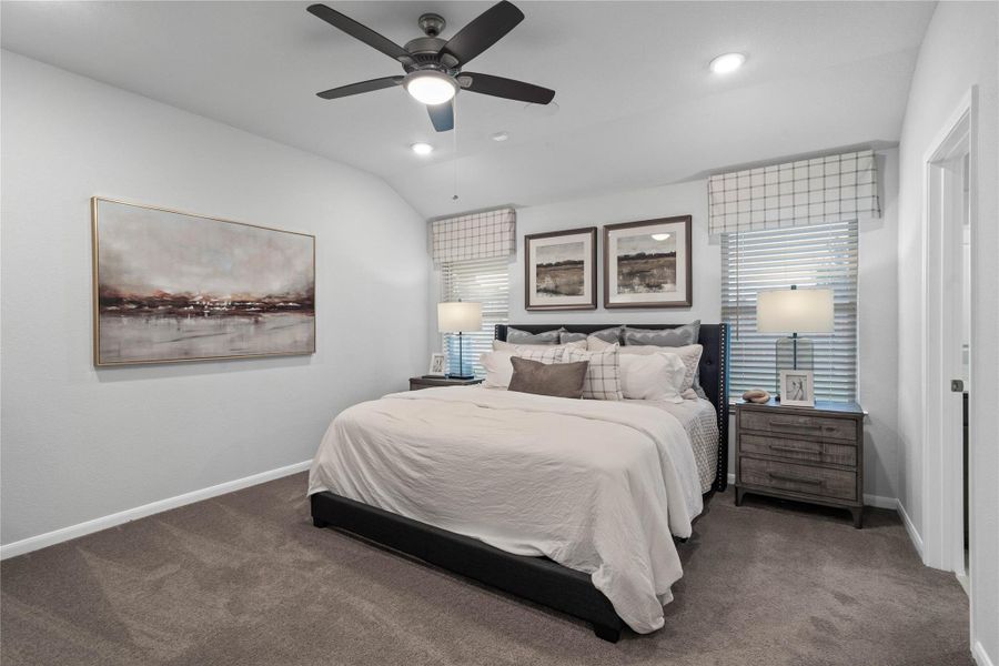 Unwind in this serene, spacious suite designed for relaxation. Features include plush carpeting, soft neutral walls, dual large windows for abundant natural light, and a modern ceiling fan for comfort.