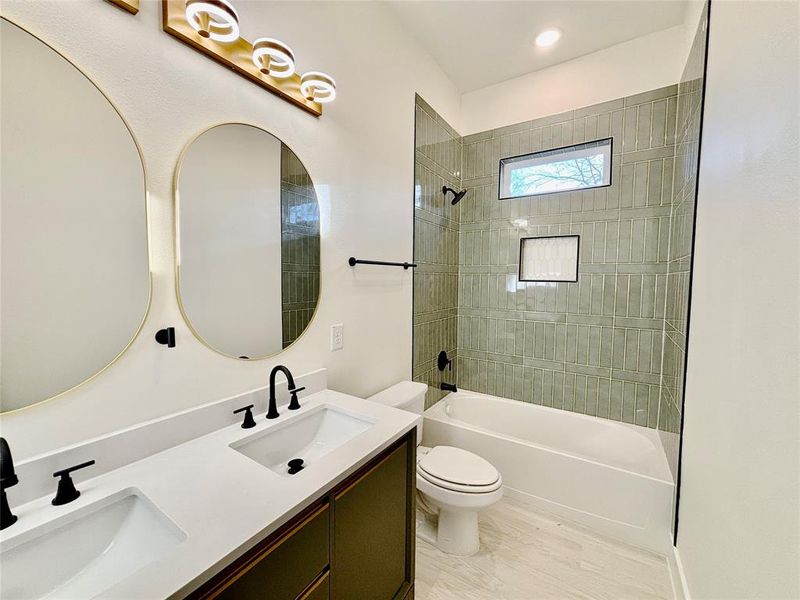 Full bathroom with double vanity and shower / bathtub combination