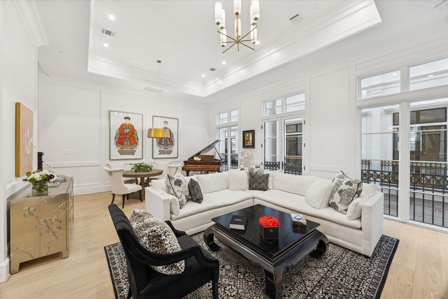 This elegant living room features a wall of windows offering natural lightingexuding a sophisticated and welcoming ambiance.