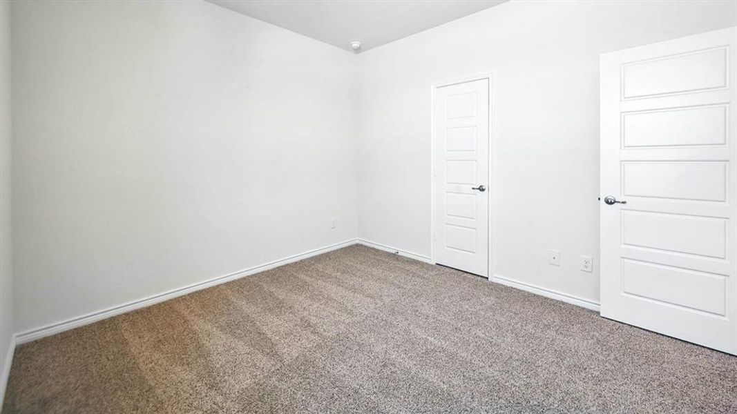 Neutral tone wall paint, textured gray carpeting, white baseboards, and two contemporary five-panel interior doors with chrome hardware