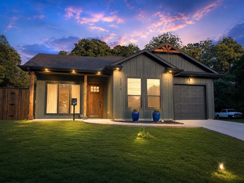Contemporary exterior featuring vertical siding, a paneled wood entry door, and an attached single-car garage