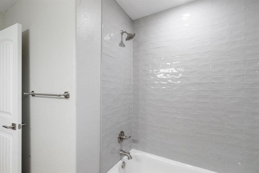 Bathroom featuring tiled shower / bath combo Bathroom featuring tiled shower / bath combo