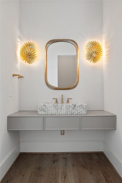 The downstairs powder room features a gorgeous floating Calcutta gold sink.