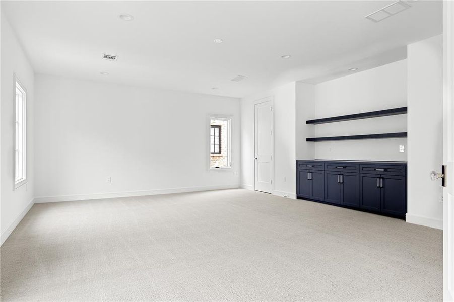 Unfurnished room with light colored carpet and recessed lighting