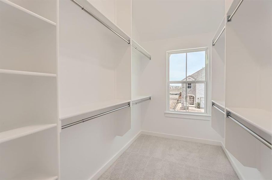 Walk in closet with light carpet