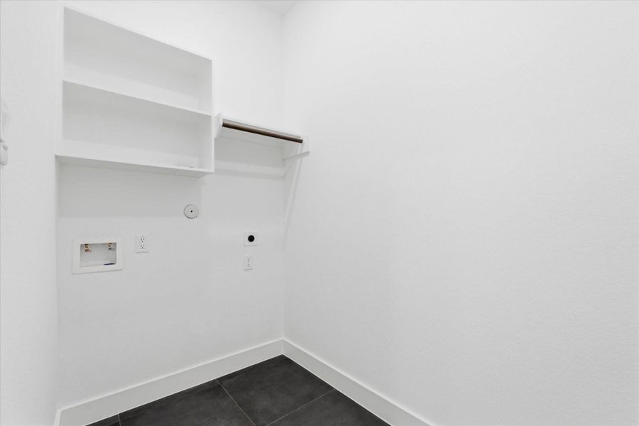 The laundry room is equipped with washer connections, an electric dryer connection, and convenient cubby storage above for additional organization.