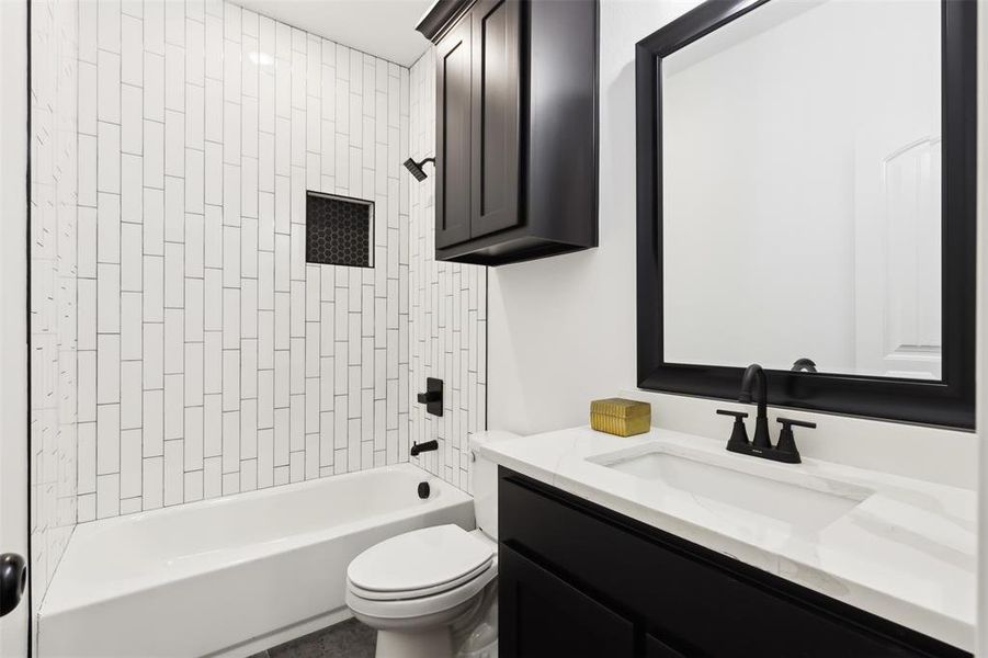 Full bathroom with toilet, vanity, and tiled shower / bath