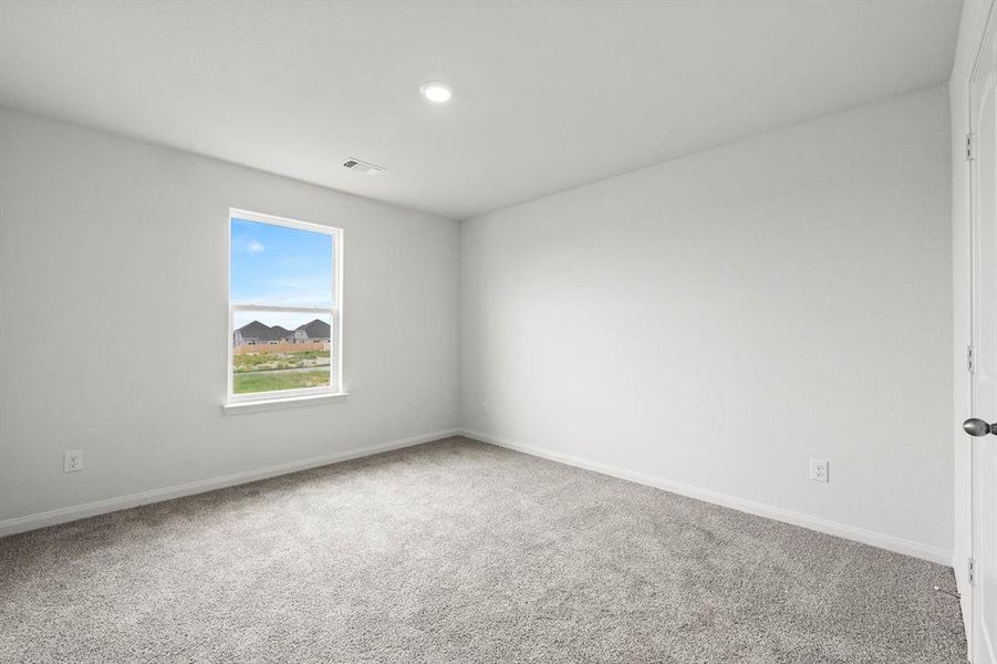 Empty room featuring light carpet and baseboards