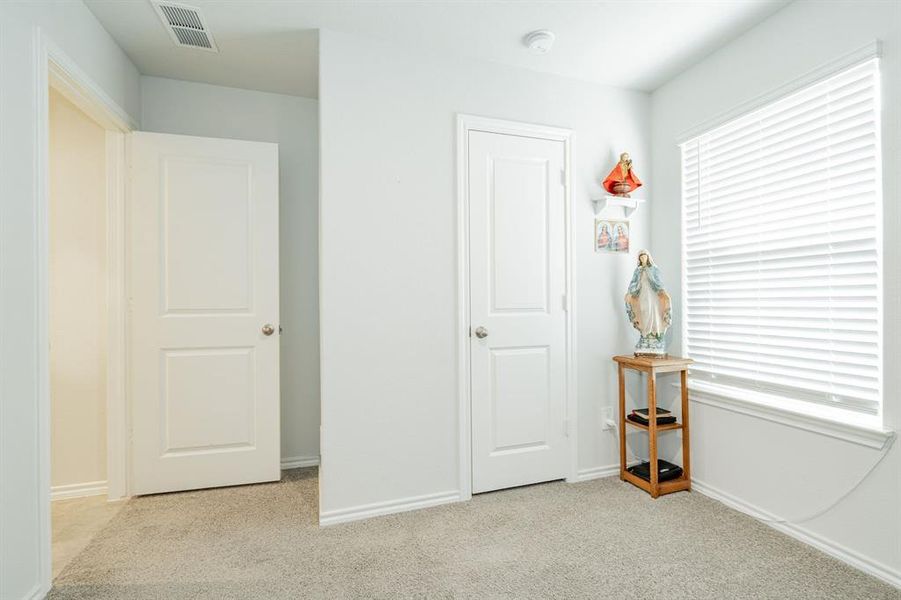 Unfurnished bedroom with visible vents, multiple windows, carpet, and baseboards