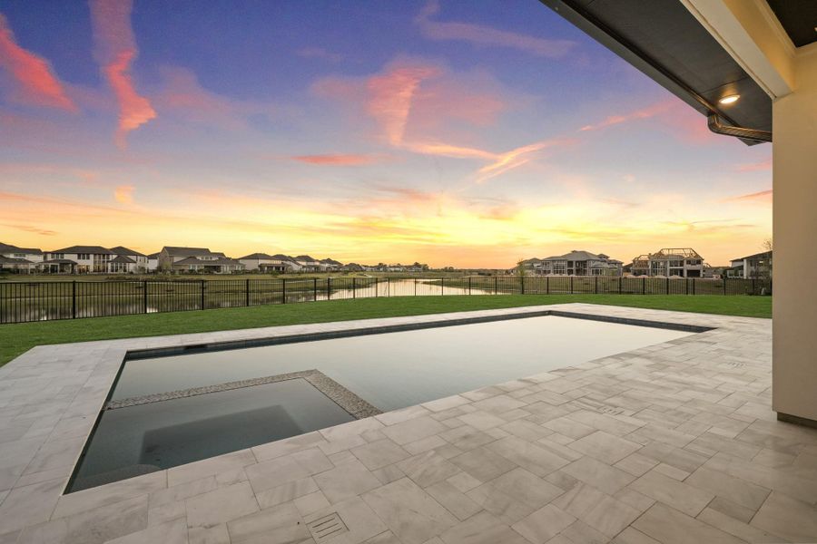 Backyard featuring a pool and hot tub alongside a spacious covered patio, overlooking a peaceful water view and surrounding neighborhood Backyard featuring a pool and hot tub alongside a spacious covered patio, overlooking a peaceful water view and surrounding neighborhood