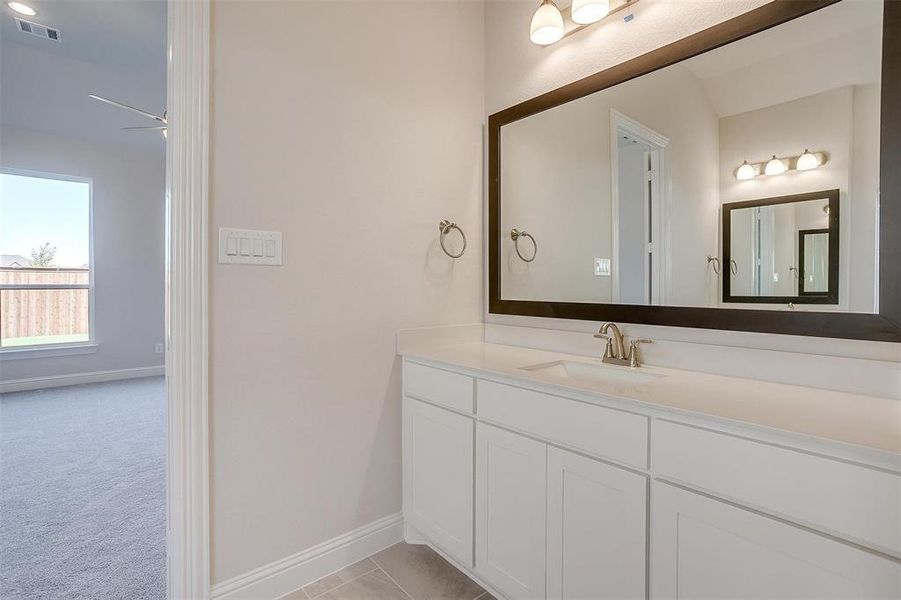 Bathroom with tile patterned flooring, vanity, ceiling fan, and lofted ceiling