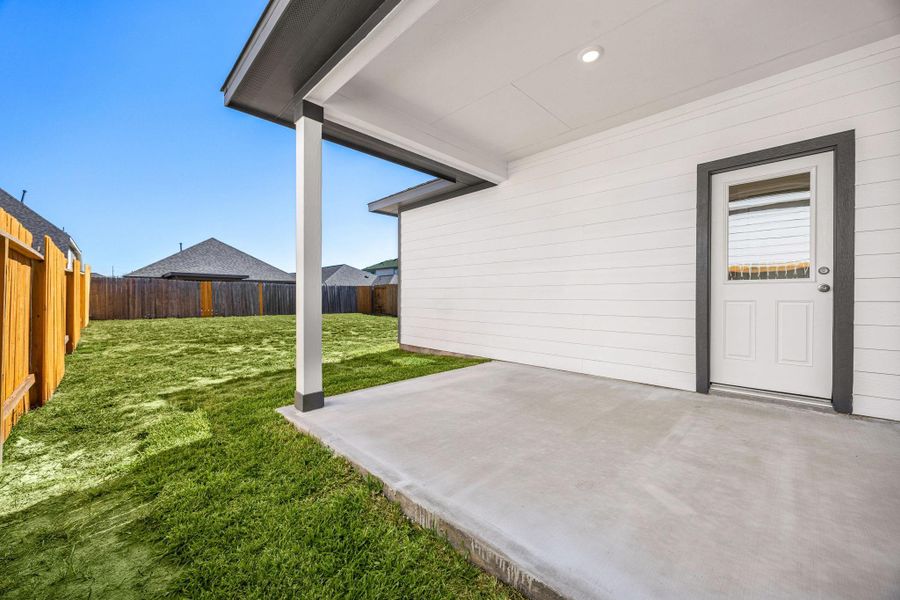 The inviting covered rear patio offers a seamless extension of indoor living to the outdoors. This spacious area features a durable concrete slab, perfect for outdoor furniture and entertaining. The inviting covered rear patio offers a seamless extension of indoor living to the outdoors. This spacious area features a durable concrete slab, perfect for outdoor furniture and entertaining.