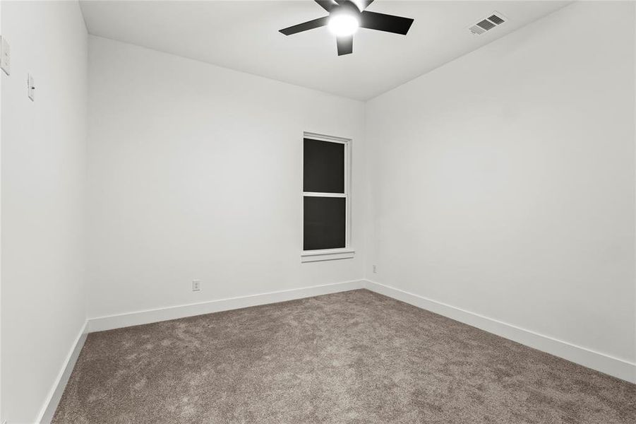 Spare room with a ceiling fan, carpet, visible vents, and baseboards