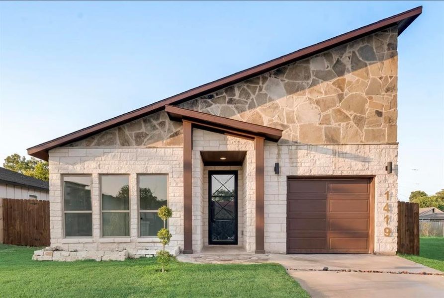 View of front facade with a garage and a front lawn