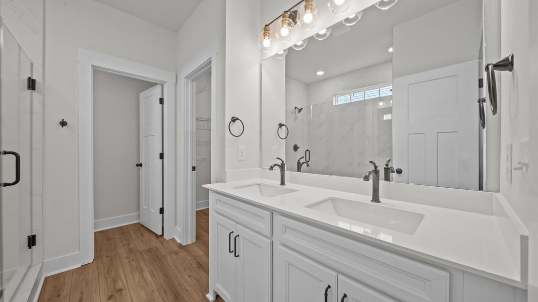 Exceptional en-suite with dual vanity and glass-enclosed walk-in shower for superior everyday comfort Exceptional en-suite with dual vanity and glass-enclosed walk-in shower for superior everyday comfort