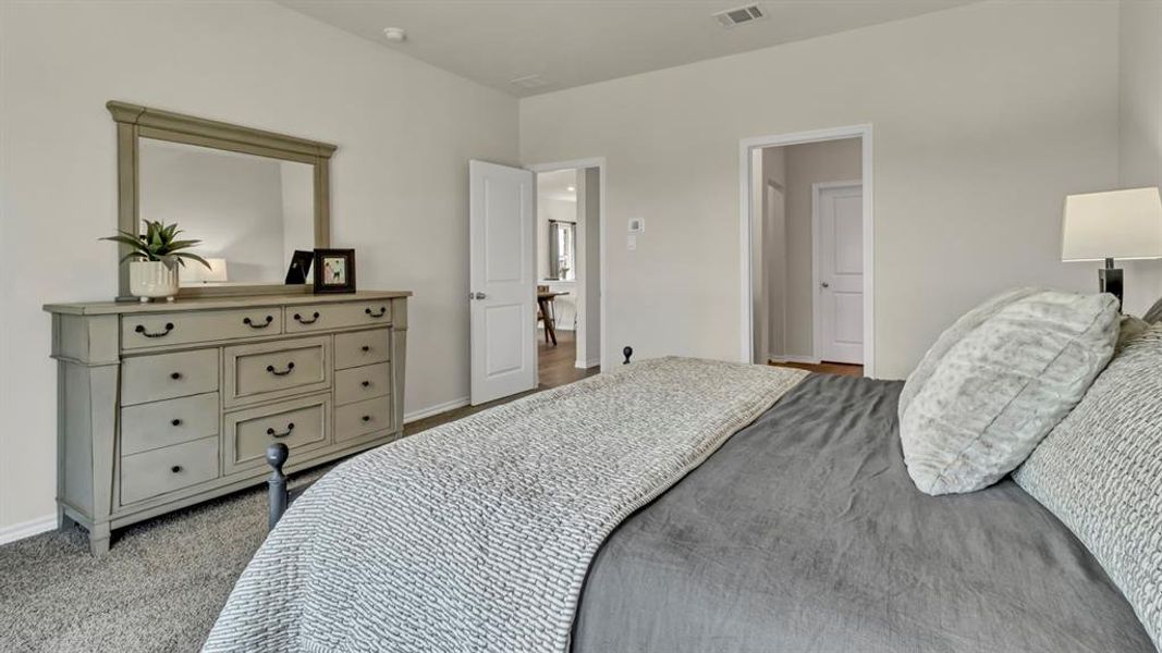 Carpeted bedroom with neutral wall paint and white trim Carpeted bedroom with neutral wall paint and white trim