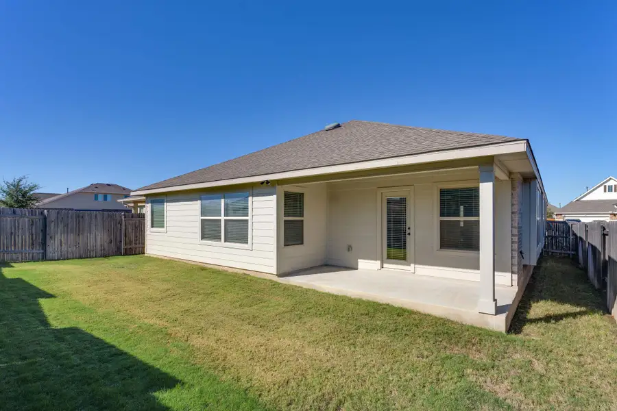 Back of house featuring a patio, a fenced backyard, and roof with shingles